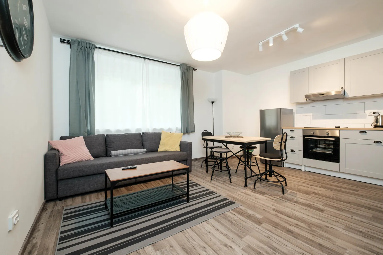Wohnzimmer mit Sofa, Esstisch und Küche